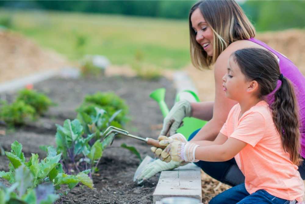 mom and daughter using garden tools